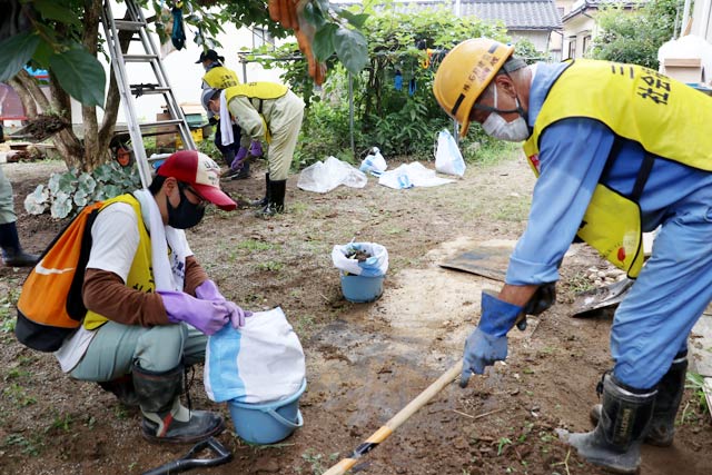 三条市ボランティアバスに参加して住宅庭の泥出し作業を行うボランティア