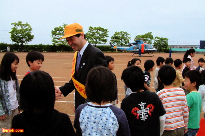 児童の出迎えに握手と笑顔の知事