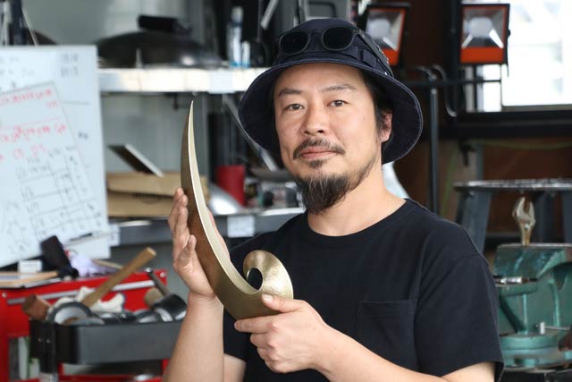 平野歩夢選手に贈られた県民栄誉賞特別賞のトロフィーを手に制作した渡邉和也さん