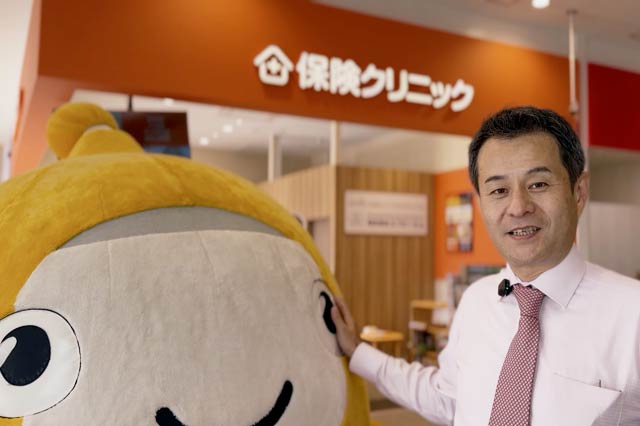 保険クリニックの前で運営するエフピーエムの嘉瀬代表取締役